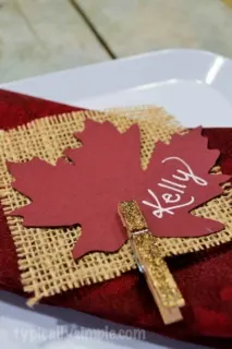A simple place card for Thanksgiving dinner using burlap and glittered clothespins.