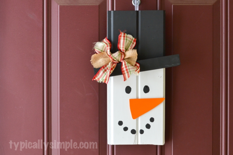 With two pieces of scrap wood, some paint, and a few other supplies from your craft stash, create this cute rustic snowman to hang on your front door!