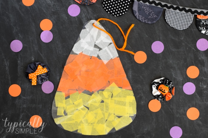 This tissue paper candy corn craft is such a fun craft to make with the kids for Halloween! Hang it in a window for a not-so-spooky sun catcher! 