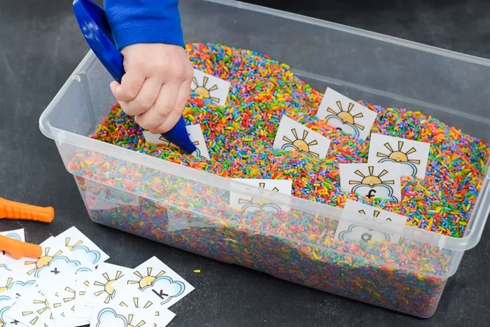 pulling alphabet cards of out sensory bin